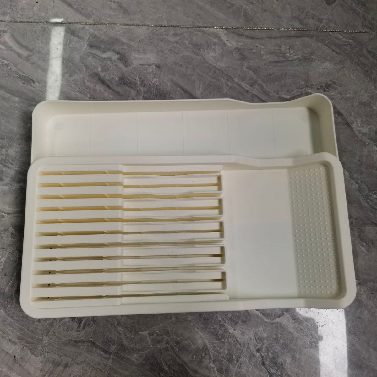 Beige bestickinsats med knivfack på grå bänkskiva