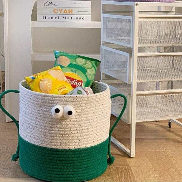 Vit och grön förvaringskorg med ögon fylld med snacks