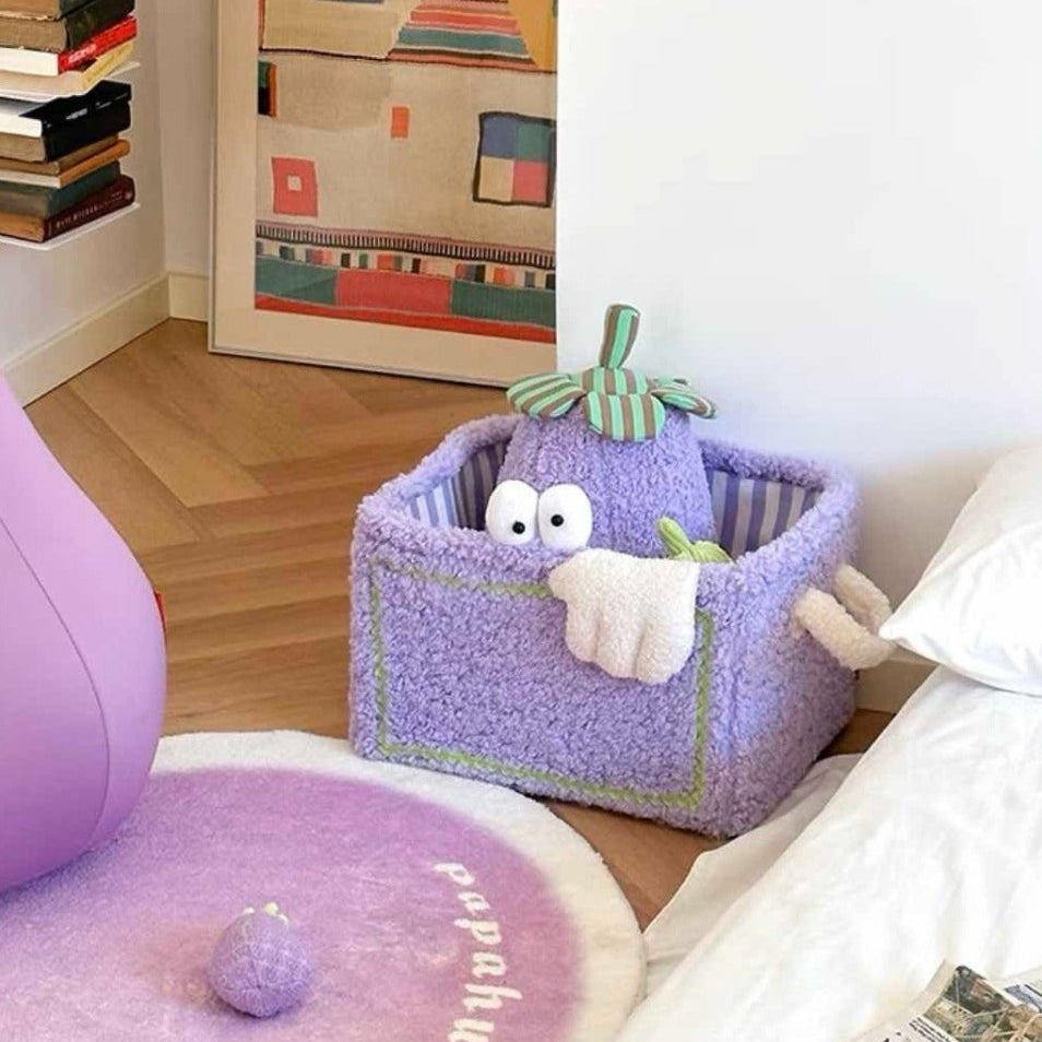 Lila plyschtvättkorg med gosedjur på golvet